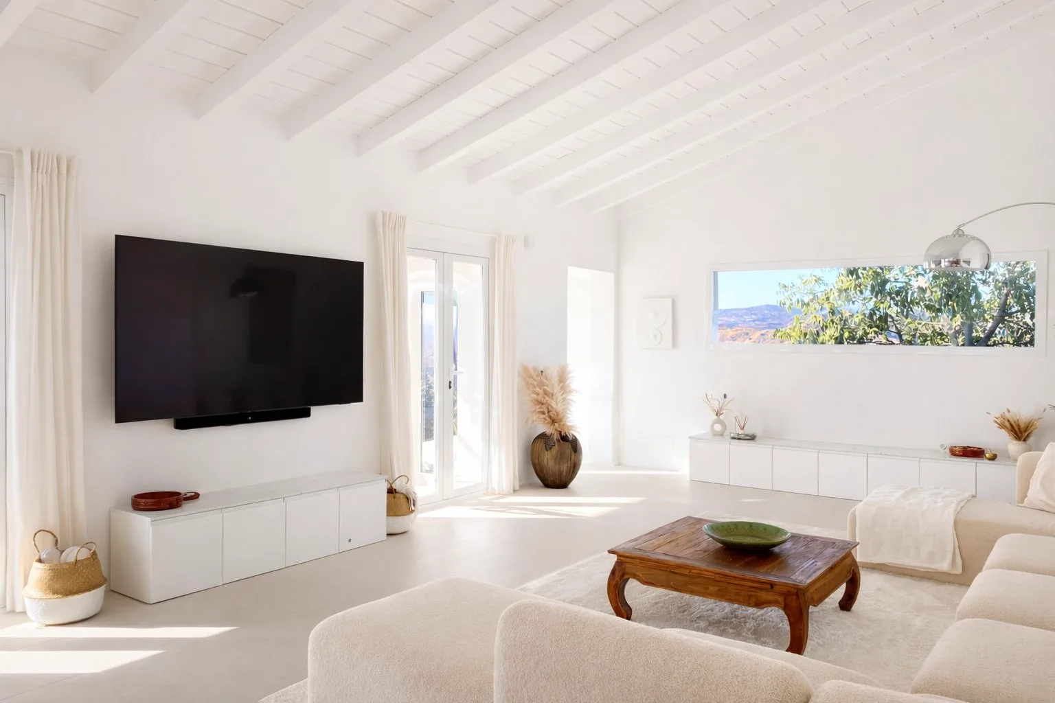 Bright open-plan living room at Casa Lux with white sofa and terrace connection