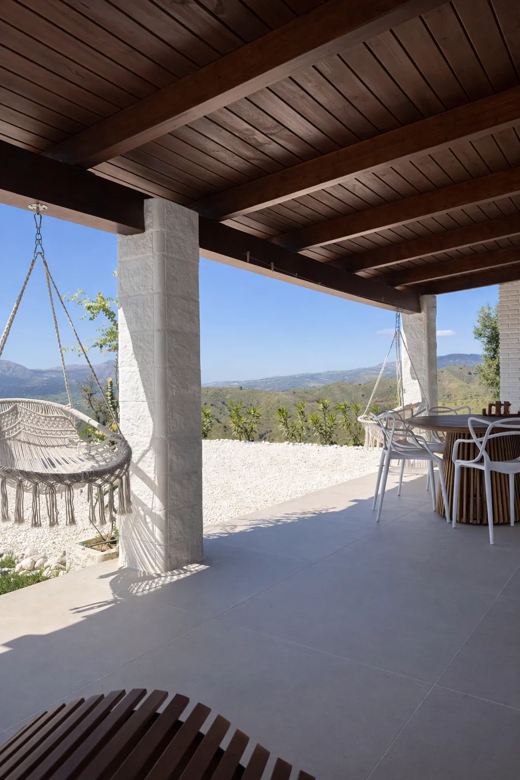 Covered dining terrace at Casa Lux with hanging swing and mountain views