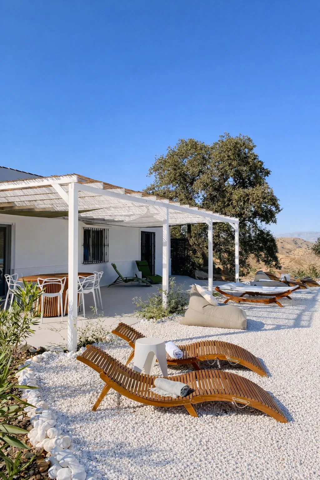 Cushioned wooden loungers and covered terrace at Casa Lux