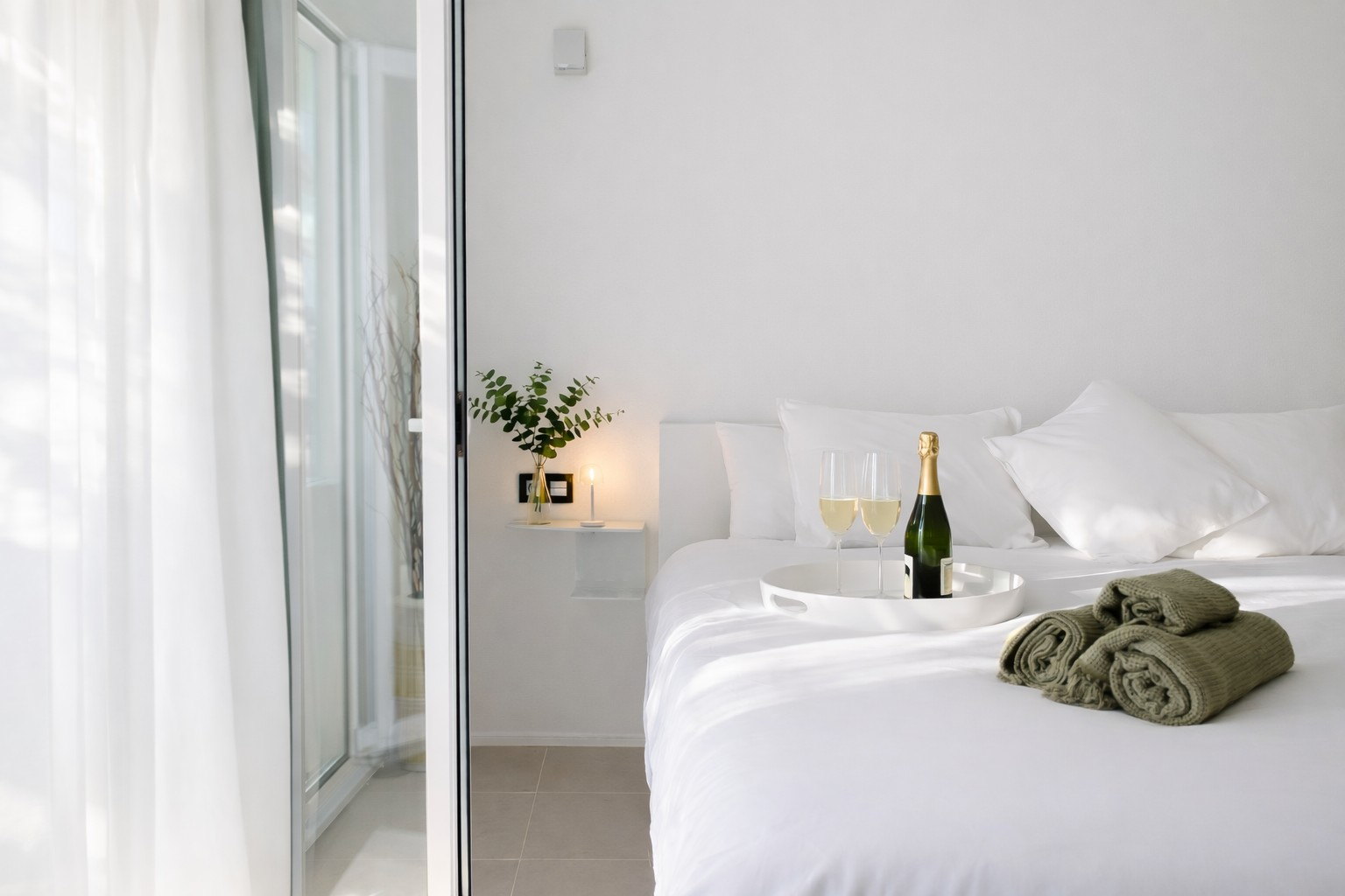 Casa Lux bedroom with champagne, towels and soft natural light