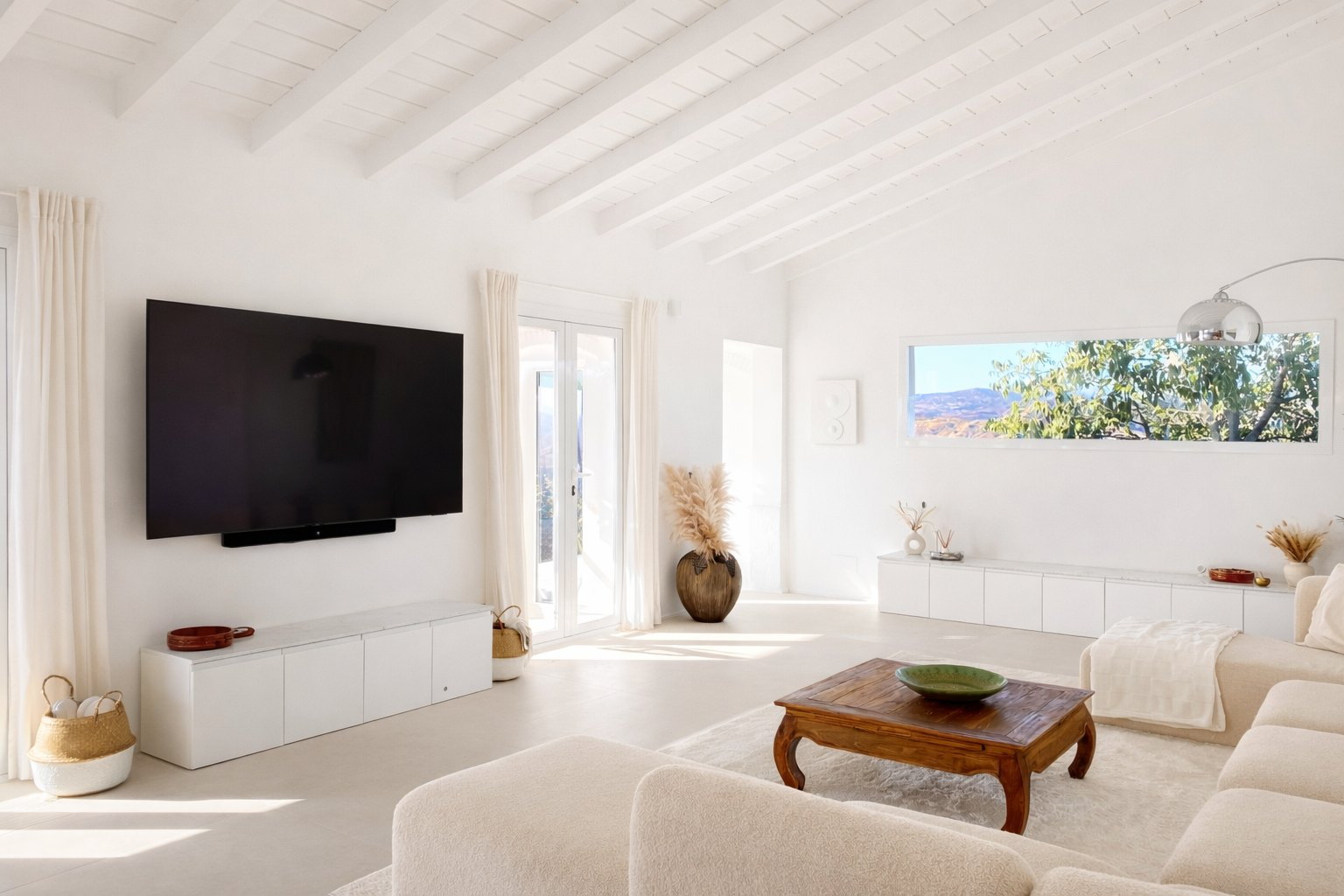 Bright open-plan living room at Casa Lux with white sofa and terrace connection